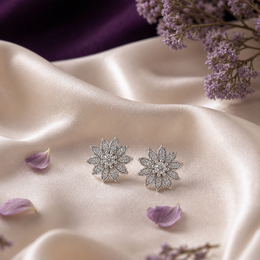 Silver floral stud earrings on ivory silk