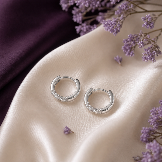 Small silver hoop earrings on ivory silk